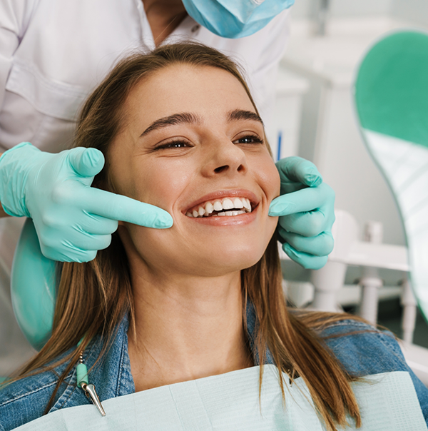 Dentist pointing to a patients smile