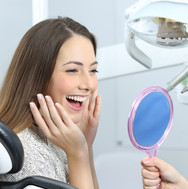 Dental patient beaming at her reflection