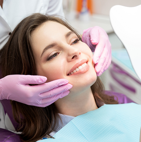 Woman leaning back in dental chair and smiling