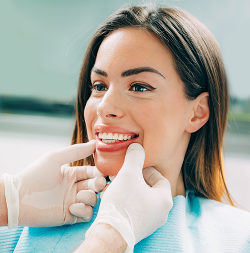 Woman in dental chair smiling at her dentist