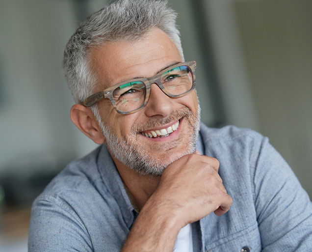 Man with gray hair and glasses smiling with dental implants in Virginia Beach