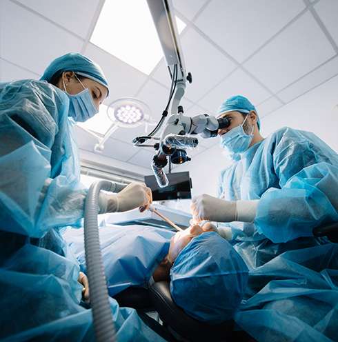 Dentist and assistant performing dental implant surgery