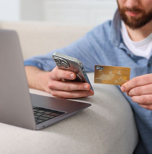 Person entering their credit card information onto a laptop