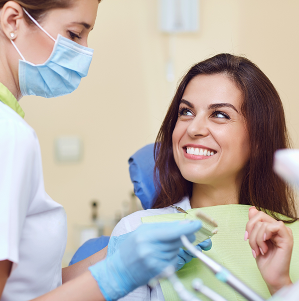 Woman smiling while listening to her dentist