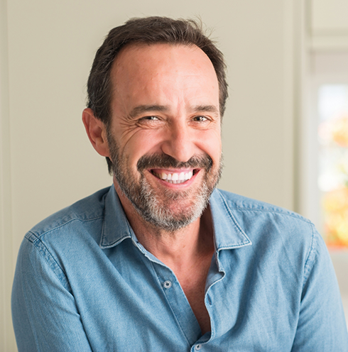 Man in denim shirt grinning