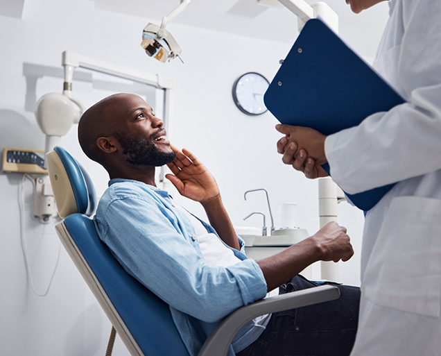 Man in dental chair talking to his emergency dentist in Virginia Beach