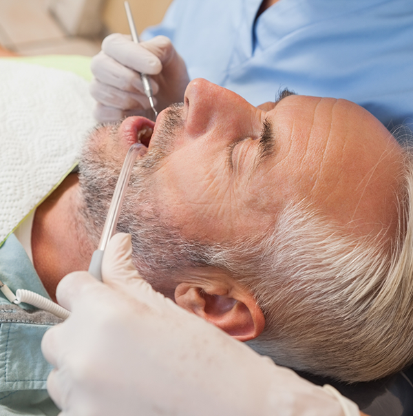 Older man having his mouth examined by a dentist