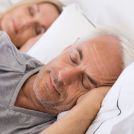 Senior man and woman sleeping soundly on their sides