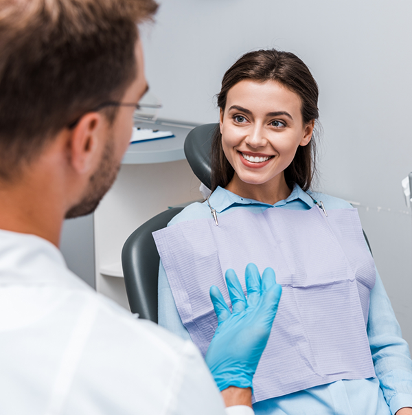 Woman in dental chair listening to her dentist