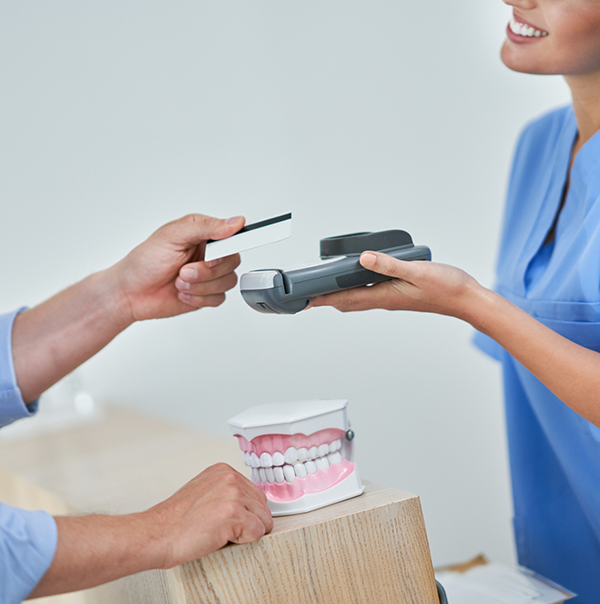 Person swiping their payment card at dental office