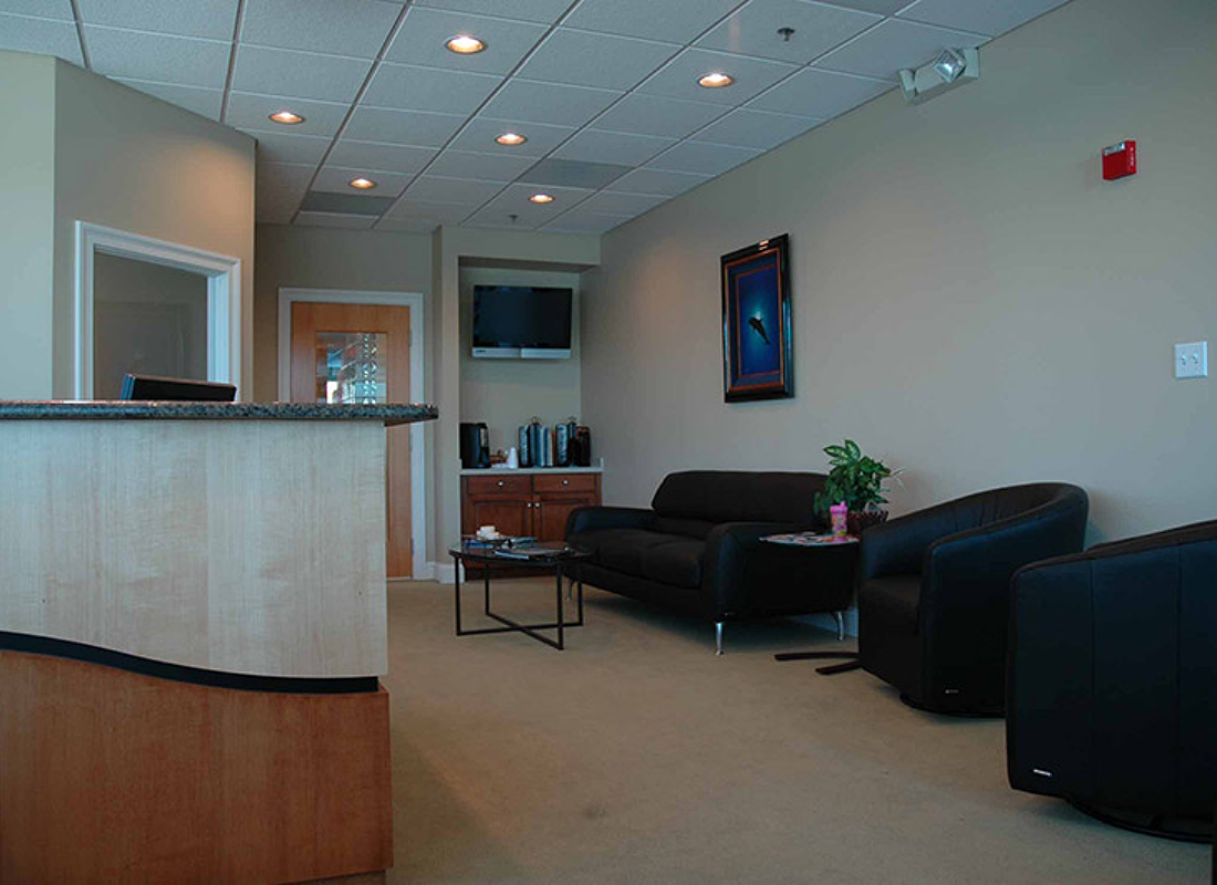 Black leather armchairs and loveseat in waiting area