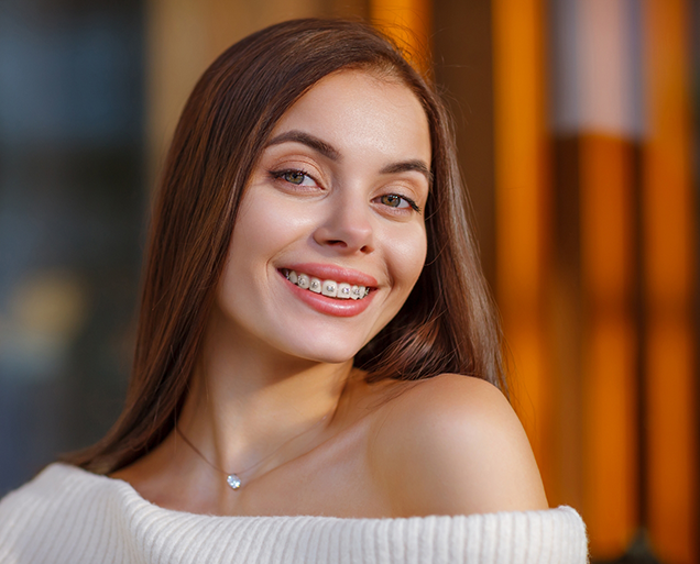 Young brunette woman with braces smiling