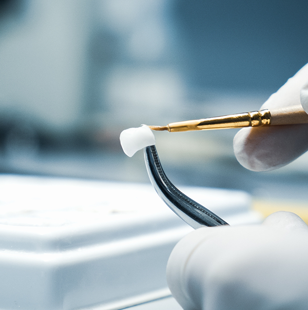 Dental ceramist carefully crafting a porcelain crown