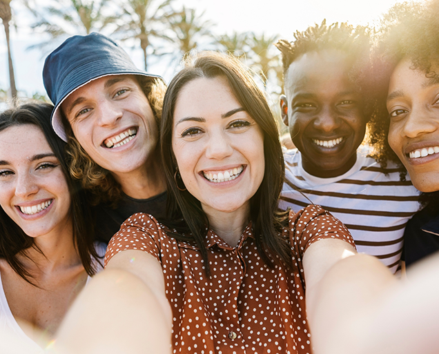 Selfie of five adults smiling outdoors after restorative dentistry