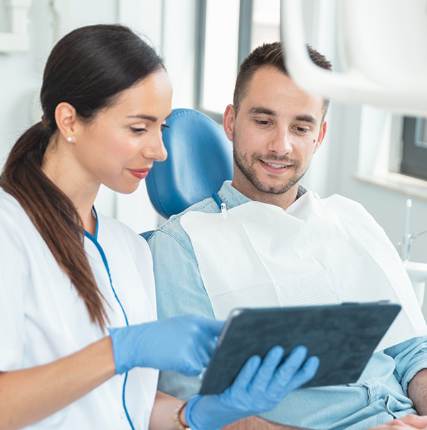 Dentist showing a tablet to a patient