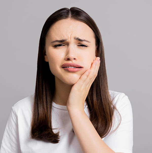 Woman wincing and holding her jaw