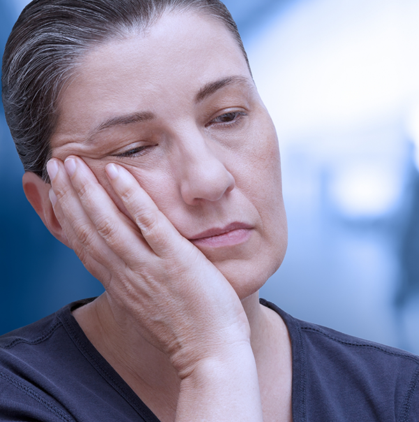 Tired person resting their face in their hand