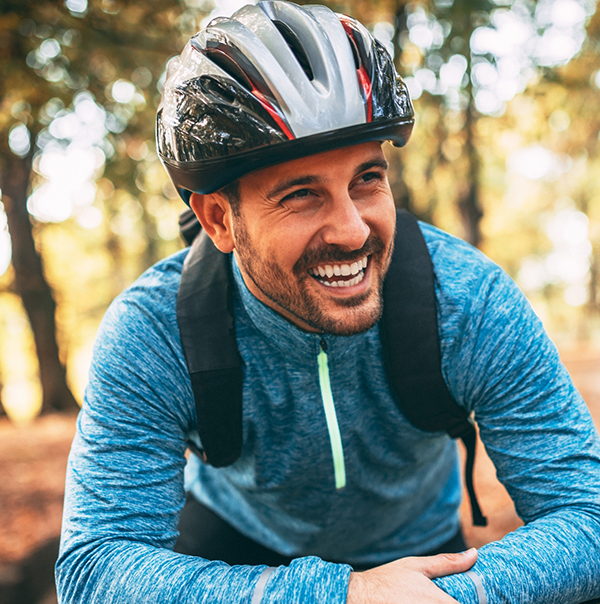 Smiling man in forest wearing biking gear