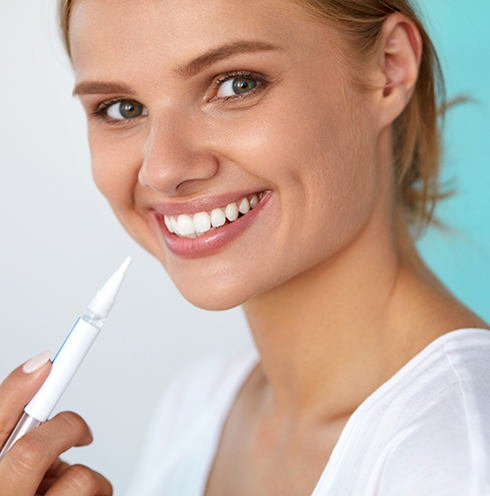 Smiling blonde woman holding a white pen