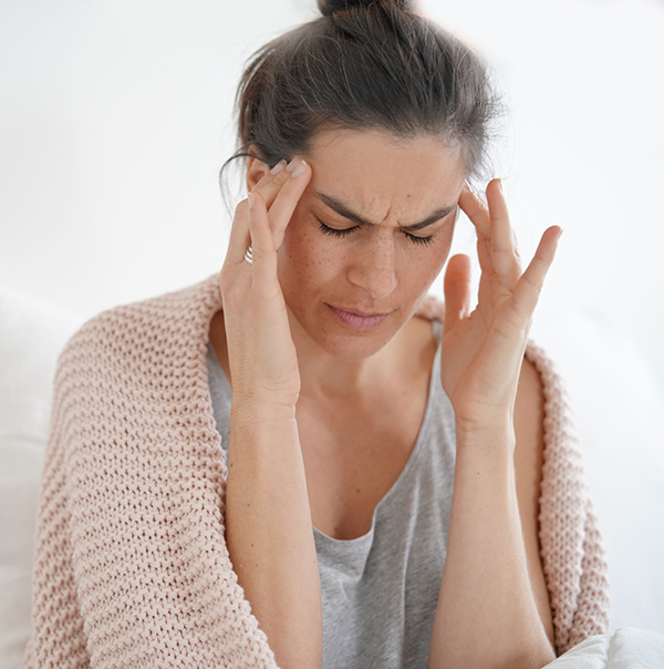 Woman rubbing her temples in pain