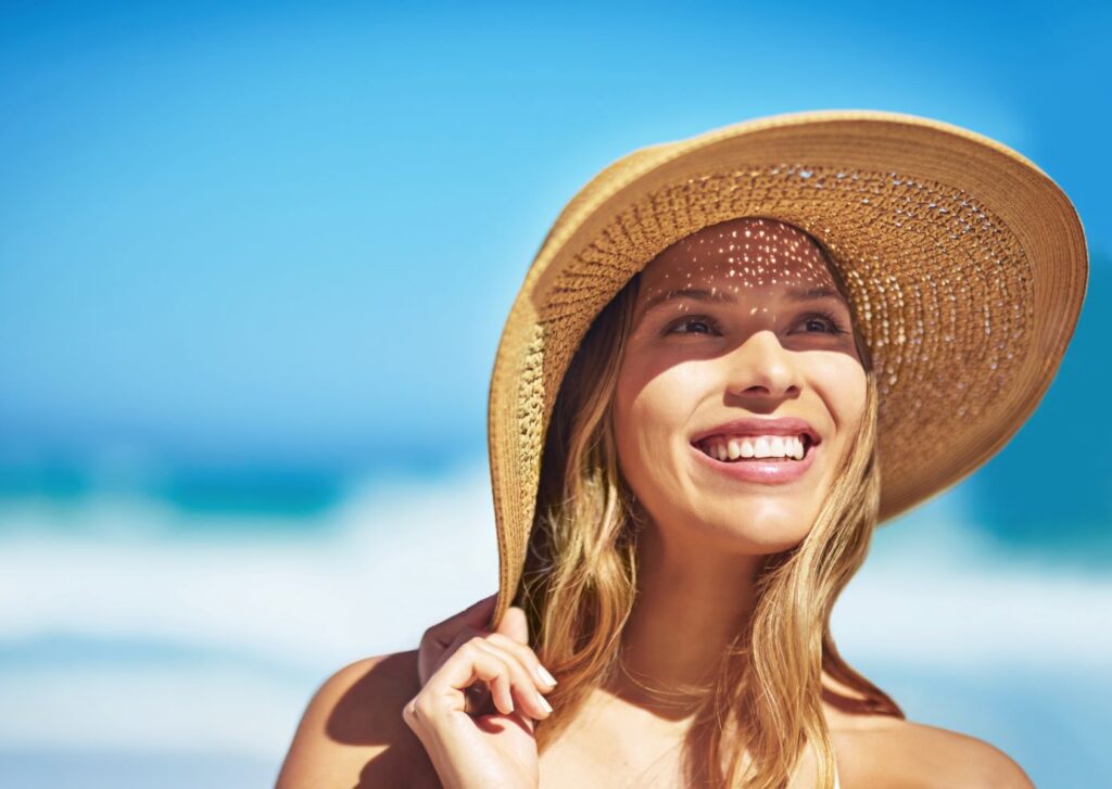 A woman in a sun hat smiling.