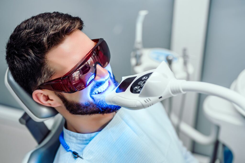 A man getting a professional teeth whitening treatment.